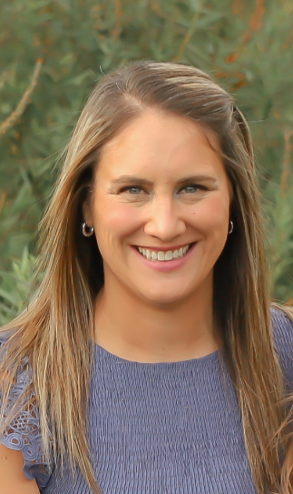 White woman with light brown hair in navy shirt; smiling